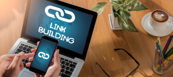 LINK BUILDING concept - a professional working on a desktop and phone for link building in SEO.